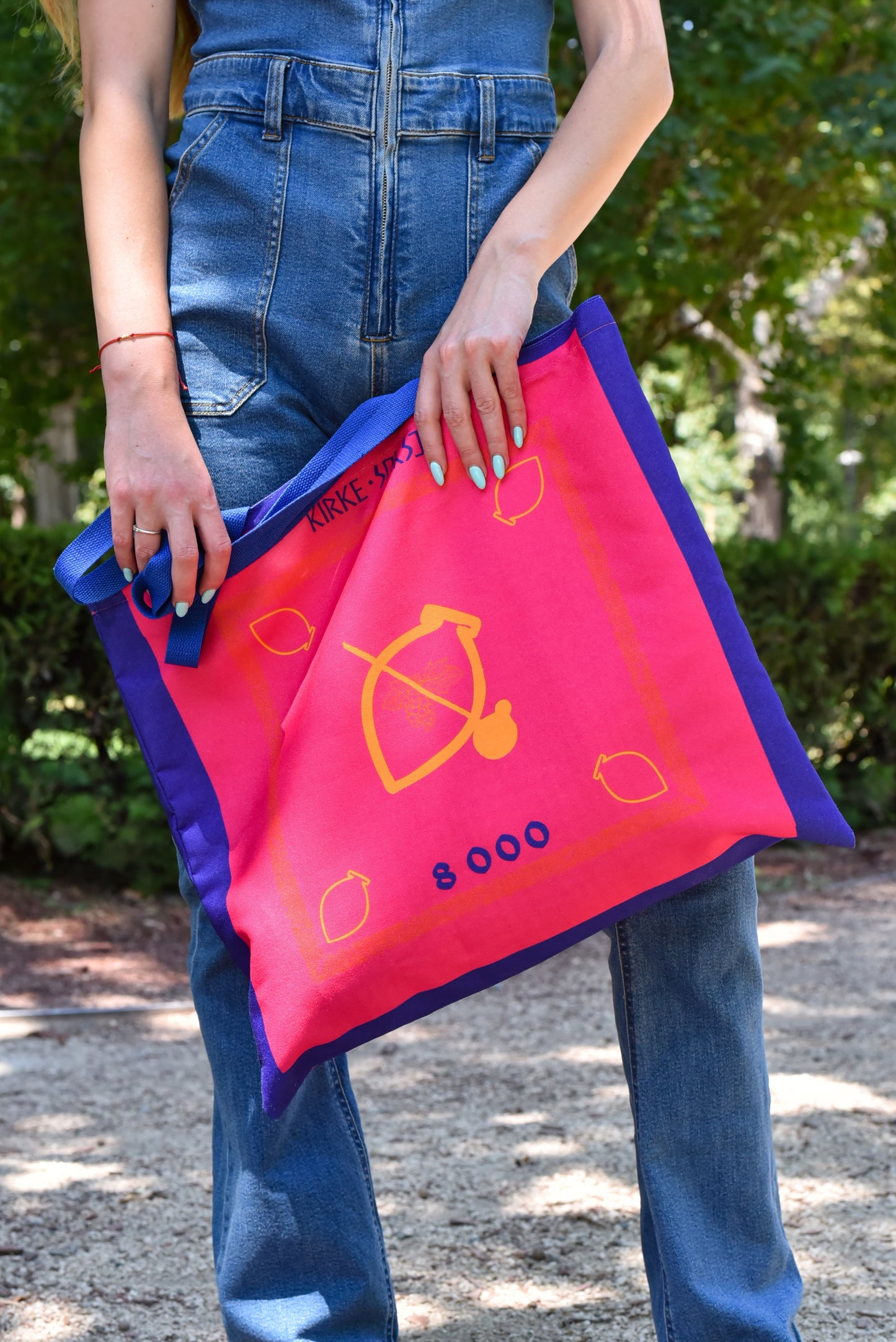 Model holding Saperavi tote bag in outdoor setting