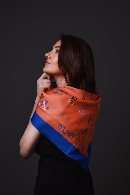 აბრეშუმის შარფი მხარზე – ასომთავრული ასოები და ტექსტურა ახლოდან