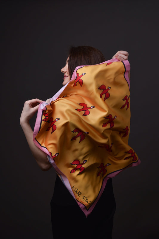 ქალი ატარებს კირკეს აბრეშუმის შარფს ფრინველების გამოსახულებით– წინა ხედით